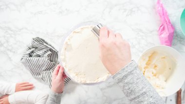 Düz yatıyordu. Adım adım. Beyaz İtalyan kremalı, yuvarlak funfetti keki..