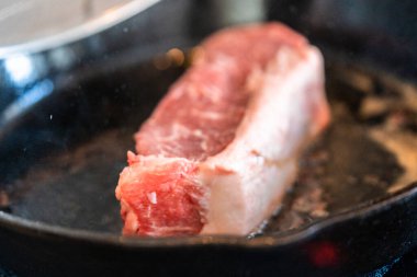 Elektrikli fırının üstünde kızgın demir tavayla New York bifteği kızartıyorum..