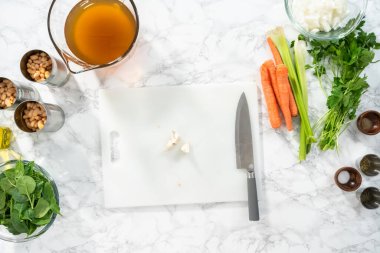 Düz yatıyordu. Beyaz bir kesme tahtasıyla organik sarımsak kesmek.