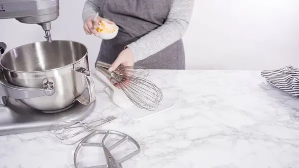 Step by step. Mixing ingredients in standing kitchen mixer to bake funfetti cake.