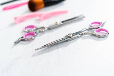 Gri arka planda pembe makasla yeni berber seti.