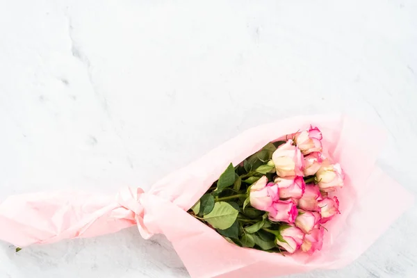 Acostado Ramo Rosas Rosadas Frescas Envoltura Papel Rosa Sobre Fondo — Foto de Stock