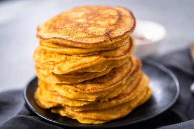 Siyah tabakta bir yığın taze balkabağı gözlemesi.