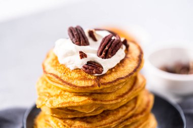 Siyah tabakta bir yığın taze balkabağı gözlemesi.