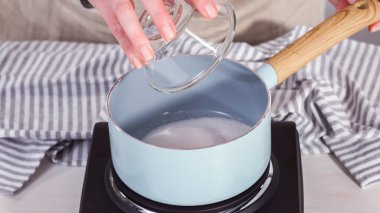 Adım adım. Elektrikli tavanın üzerine küçük bir tencereyle şeker şurubu hazırlıyorum..