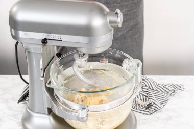 Ev yapımı brioche çörekleri pişirmek için mutfak mikserindeki malzemeleri karıştırıyorum..