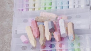 Evin önünde tebeşirle oynayan küçük bir kız..