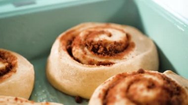 Taze pişmiş tarçınlı çörekleri mavi bir tavada jölelemek.