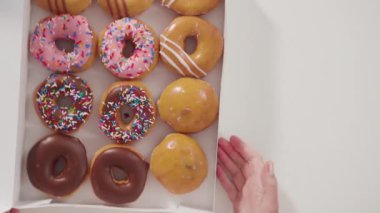  Beyaz bir karton kutuda mağazadan alınmış donutların çeşitliliği.