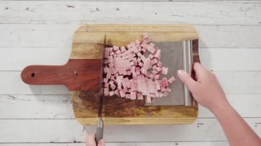 Ağaç kesme tahtasıyla organik ballı jambon kesmek.