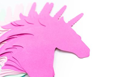 Düz yatıyordu. Beyaz arkaplanda renkli tek boynuzlu at kağıt kesitleri.