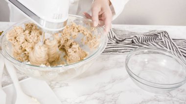 Adım adım. Çikolata parçacıklı kurabiye yapmak için cam kasede malzemeleri karıştırıyorum..