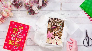 Düz yatıyordu. Adım adım. Ev yapımı şekerleme ve kurabiyeleri Noel hediyesi kutusuna koymak.