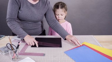 İnşaat kağıdından el yapımı Babalar Günü kartı yapan küçük bir kız..