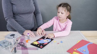 İnşaat kağıdından el yapımı Babalar Günü kartı yapan küçük bir kız..