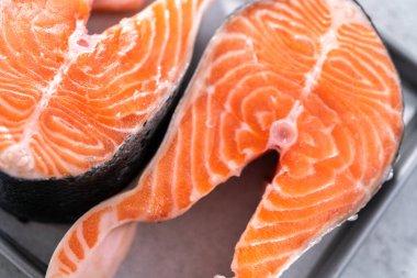 Parşömen kağıdıyla pişirme tepsisinde çiftlik somonu bifteği..