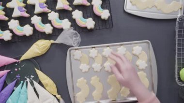 Gökkuşağı şekerli kurabiyeleri pasta tepsisinde kraliyet kreması ile süslemek.