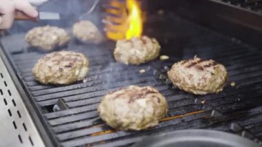 Gaz ızgarasında hamburger köftesi pişirmek..