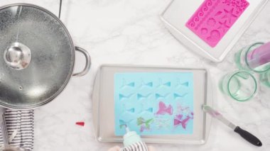 Üzerinde mavi tereyağlı krema süslemesi ve çikolata denizkızı kuyruğu ile süslenmiş gurme deniz kızı kekleri..