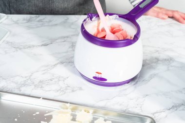 Çikolata parçacıklarını eriterek..