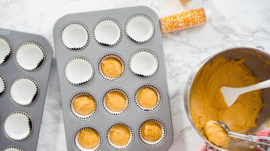 Düz yatıyordu. Balkabağı aromalı kek hamuru. Hamur hamuru kepçesiyle kapkek tepsisine dolgu malzemesi..