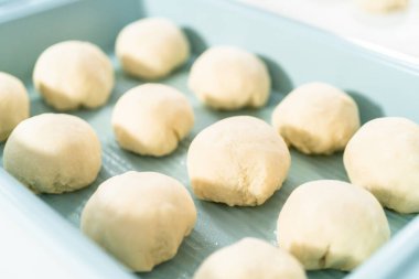 Beyaz bir tezgahın üzerinde mayalı hamurla yemek pişiriyorum..
