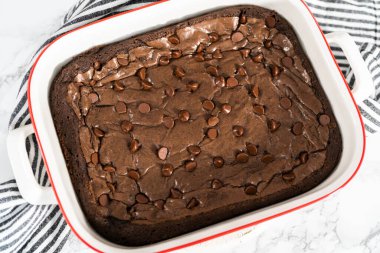 Üstünde ekstra çikolata parçacıkları olan ev yapımı brovniler pişiriyorum..