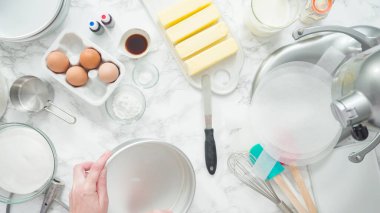 Adım adım. Düz yatıyordu. Üç katlı vanilyalı kek pişirmek için tereyağlı kek tavaları yağlamak..