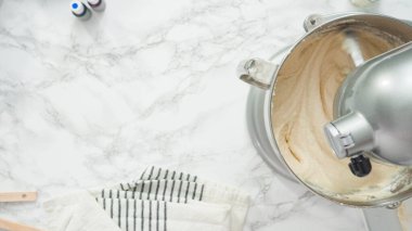 Adım adım. Düz yatıyordu. Üç katlı vanilyalı kek pişirmek için mutfak mikserinin malzemelerini karıştırıyorum..