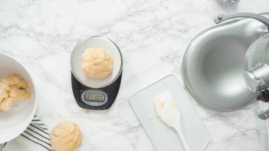 Adım adım. Düz yatıyordu. Kırmızı, beyaz ve mavi fırıldak şekerli kurabiyeler pişirmek için dijital mutfak terazisiyle ölçülmüş kurabiye..