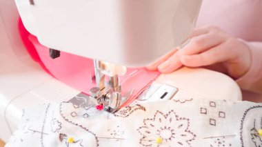 Koronavirüs salgını için dikiş makinesiyle pamuk yüz maskesi dikiyorum..