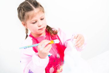 Küçük kız COVID-19 salgınında evde uzaktan öğrenim için sanat projesi üzerinde çalışıyor..