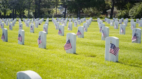 コロラド州デンバー2019年5月26日 記念の日にフォートローガン国立墓地の白い大理石の墓石の横にある小さなアメリカ国旗 — ストック写真