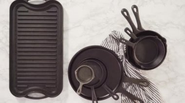 Mermer zemin üzerinde dökme demir tavaların çeşitliliği.