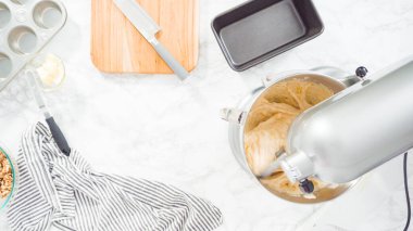 Düz yatıyordu. Adım adım. Muz ekmeği pişirmek için malzemeleri metal karıştırma kabına karıştırıyorum..