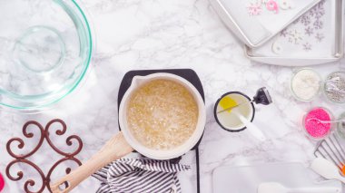 Düz yatıyordu. Adım adım. Küçük elektrikli ocağın üzerinde küçük bir tencerede karamelize şeker.