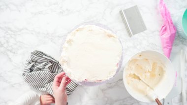 Düz yatıyordu. Adım adım. Beyaz İtalyan kremalı, yuvarlak funfetti keki..