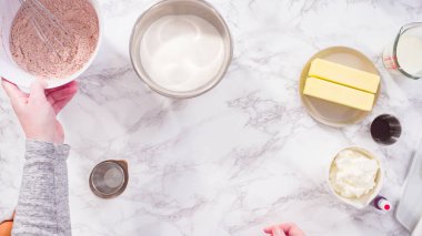 Düz yatıyordu. Adım adım. Kırmızı kadife kek pişirmek için kuru malzemeler karıştırıyorum..