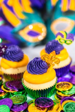 Mardi Gras vanilyalı kekler folyo kaplarda ve İtalyan tereyağlı kremayla süslenmiş..