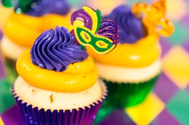 Mardi Gras vanilyalı kekler folyo kaplarda ve İtalyan tereyağlı kremayla süslenmiş..