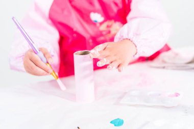 Tuvalet kağıdından tek boynuzlu at yapan küçük bir kız..