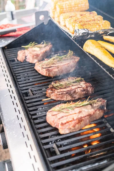 Grillowanie Nowojorskiego Steku Kawałkiem Masła Rozmarynu Grillu Gazowym Świeżym Powietrzu — Zdjęcie stockowe