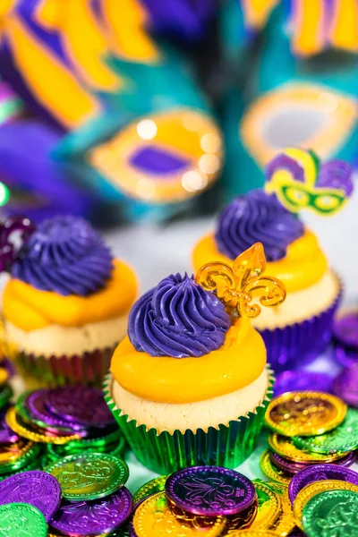 Mardi Gras vanilyalı kekler folyo kaplarda ve İtalyan tereyağlı kremayla süslenmiş..