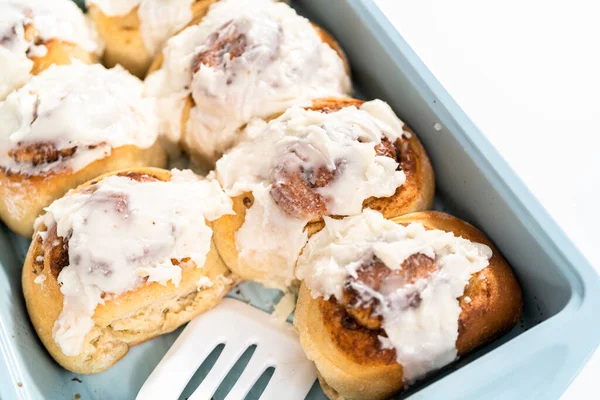 Vers Gebakken Kaneelbroodjes Met Witte Glazuur Een Blauwe Bakvorm — Stockfoto