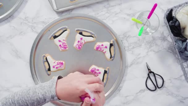用粉色皇家糖霜装饰溜冰鞋形的糖饼干 — 图库视频影像