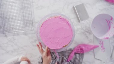 Pembe tereyağlı krema kaplı yuvarlak funfetti kek katmanları.