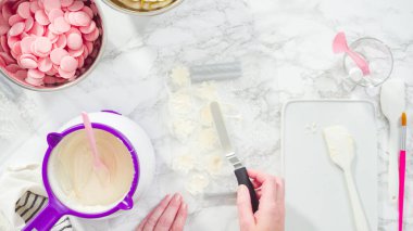 Düz yatıyordu. Adım adım. Erimiş çikolatayı kar taneleri şeklinde plastik bir çikolata kalıbına döküyorum..