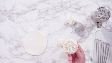 Düz yatıyordu. Adım adım. Mermer tezgahın üzerindeki beyaz fondanla kar tanelerini keserek..