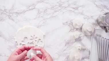 Düz yatıyordu. Adım adım. Mermer tezgahın üzerindeki beyaz fondanla kar tanelerini keserek..