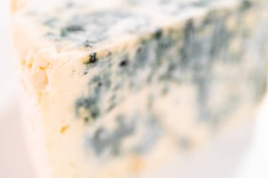 Beyaz arka planda büyük bir dilim mavi peynir..